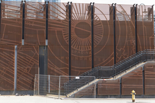 rust-colored perforated corten steel barrier wall with abstract historical mappings designed by IBI Group installed at Copeland Transformer Station northeast corner of Rees St and Lake Shore Blvd W, T