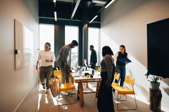 Team members moving around workspace during busy workday