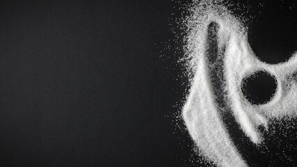 Top view of spilled sugar scattered across deep black background, creating striking contrast and minimalist composition. Large empty copy space for product placement or advertising text.  © magdal3na