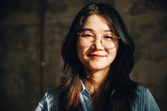 Portrait of smiling businesswoman with long hair wearing eyeglasses