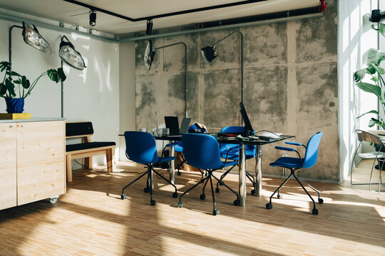 Modern office interior with blue chairs and glass meeting table