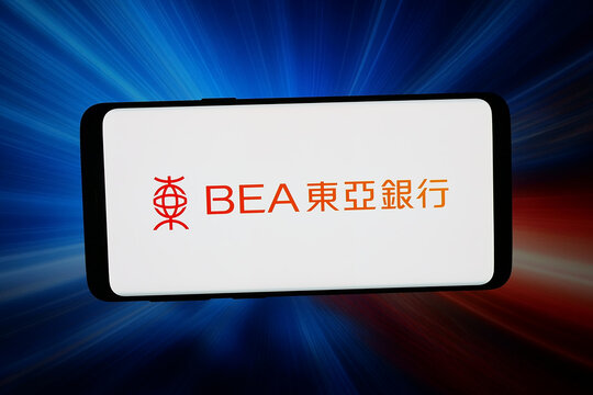 Stuttgart, Germany - 04-27-2026: In this photo illustration, the logo of company The Bank of East Asia Limited (BEA) is displayed on a smartphone in front of abstract background on computer screen.