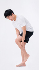 Obraz premium Muscle Strain and Discomfort: A person, captured in a clinical portrayal, visibly experiences pain, clutching his injured leg.