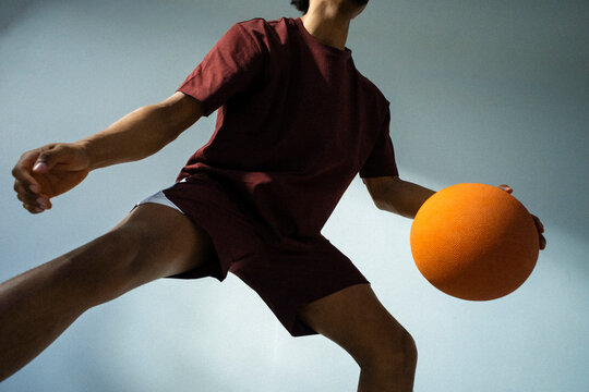 Low angle midsection view of young man showing basketball skills
