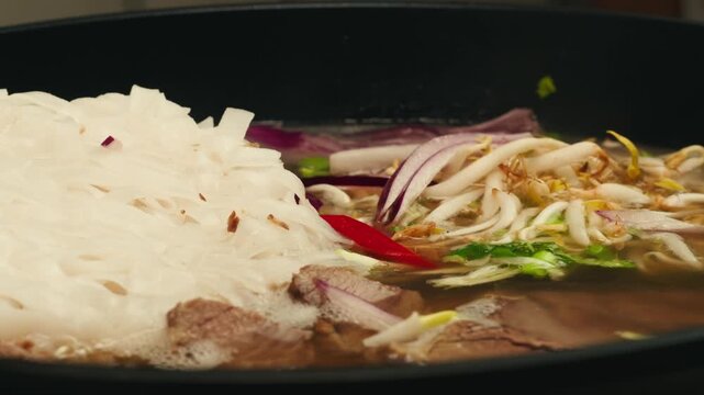 Vietnam traditional pho bo soup on delivery, Beef noodles. Pho Bo Soup with beef, rice noodles, ginger, lime, chili pepper in bowl. Vietnamese cuisine. Pho Noodle Soup restaurant Close-up.