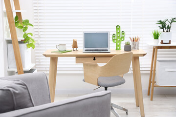 Fototapeta premium Stylish workplace with laptop and stationery in child's room
