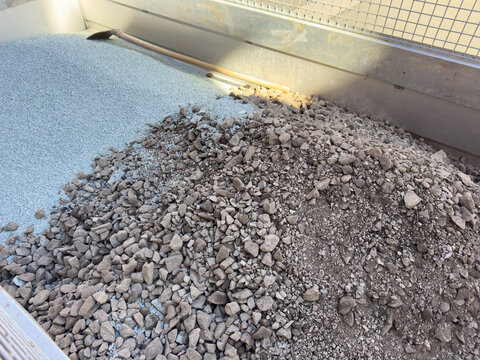 Frost protection material and gravel on a trailer at a residential construction site.