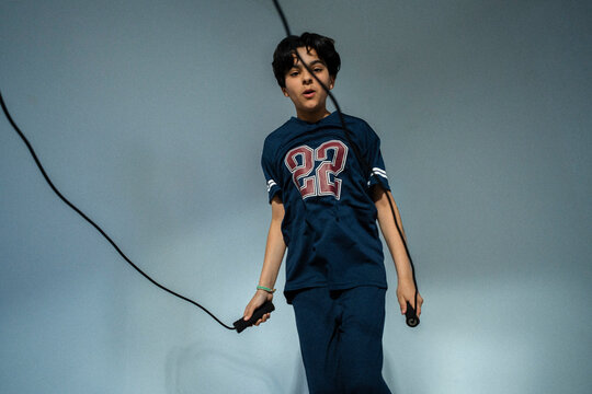 Low angle view of determined boy exercising with jumping rope