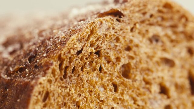Black rye bread close up, dark brown sliced loaf, borodinsky slavic food, square slices with coriander on white background