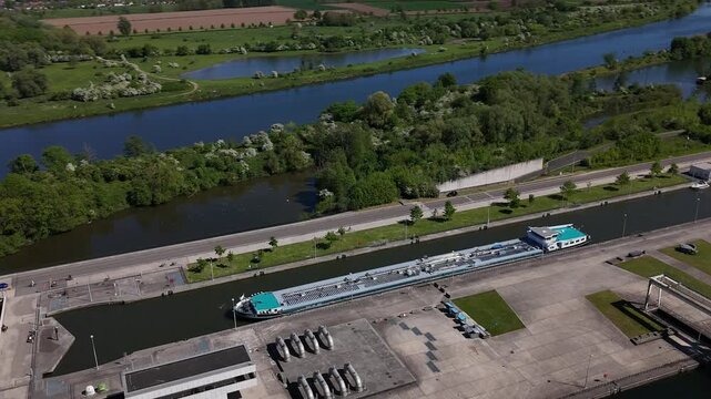 Barge passes through lock on River Maas near Maastricht at Ecluse de Lanaye between Belgium and Netherlands