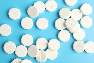 Obraz premium Many pills on light blue background, flat lay