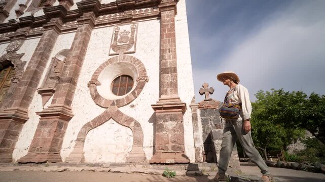 Mature woman walks and enjoys the beauty of Mission Church in San Ignacio, Mexico while sightseeing in the area.