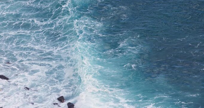 Sea waves creating soft water textures nature background and rolling toward beach shore aerial landscape view