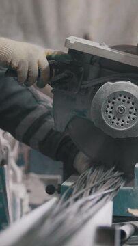 Manufacture of composite fiberglass reinforcement - worker cuts wires with circular saw