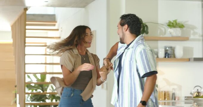 Couple African American man and woman entering home greeting spinning hugging near staircase island