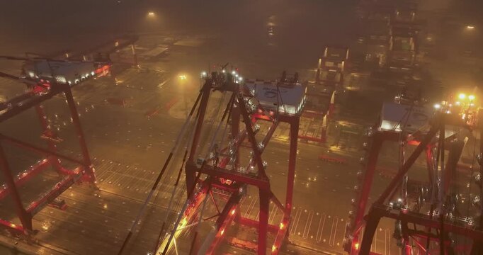 Foggy Night Aerial View of Illuminated Container Port Cranes