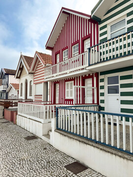 Traditional colorful striped houses along the street in Costa Nova, Aveiro, Portugal. Iconic Palheiros architecture.