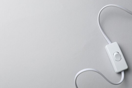 Cord switch for lamp on light grey background, top view. Space for text