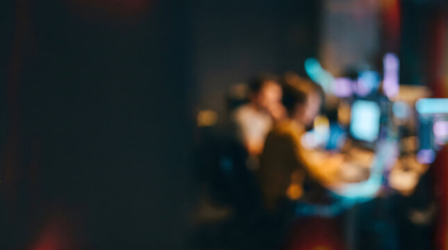 Moody blurred person working on computer in a dark modern office