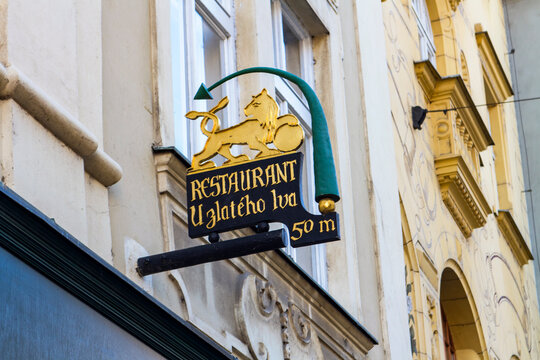 Prague, Czech Republic - November 12, 2015: The ornate golden lion sign for Restaurant U Zlateho lva hangs from a historic building facade, welcoming visitors to the charming streets of the Old Town.