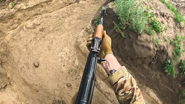 Infantry soldier advancing forward and firing a machine gun during active combat. Close-up of the weapon in action. Concept of real battle, frontline movement, and military engagement under combat