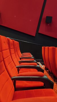 Empty row of red push back chairs or seats inside theater hall. Flop opera, film, concert, cinema or movie concept.