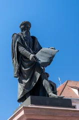 Gutenberg statue in Strasbourg stands tall under clear blue sky © Claudia Nass