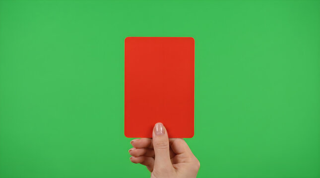 Hand holding a red card against a green background, symbolizing a penalty or expulsion