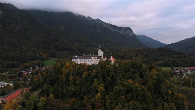 Overcast aerial, Hohenaschau Castle in mountain mist. Schloss Hohenaschau, Aschau im Chiemgau, Chiemgauer Alpen. Aerial video, Schloss Hohenaschau, Bavaria. Drohnenflug, Kampenwand, Nebel im Tal