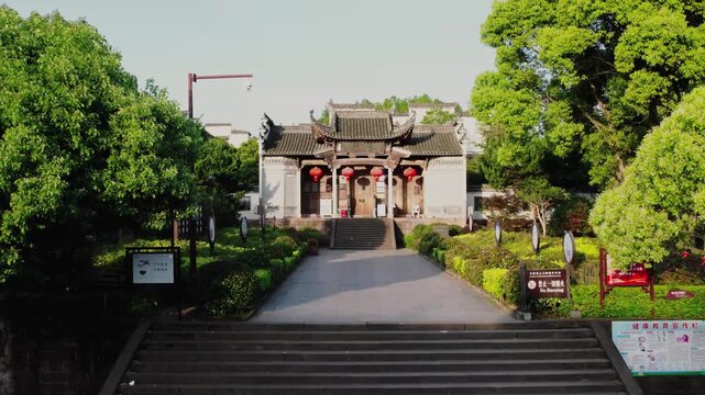 Traditional Chinese Temple Entrance with Stone Steps and Green Trees