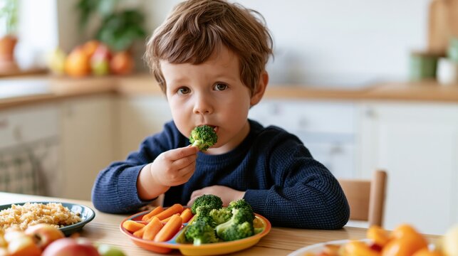 Young child cautiously tries a piece of broccoli from a colorful plate