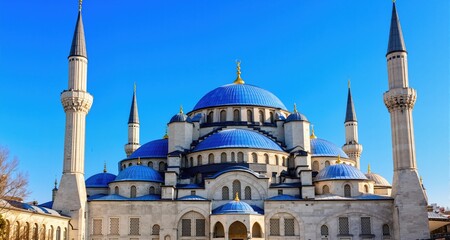 Fototapeta premium Majestic blue domes minarets a mosque shine under a clear blue sky. 
