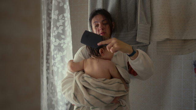 Mother drying baby with towel and brushing wet hair after bath, gentle parenting care and nurturing bedtime routine