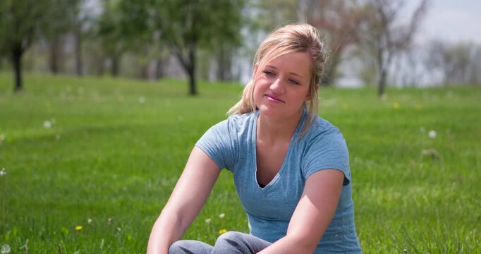 Girl sitting in grass on sunny day 4k

