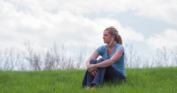 Girl smiling sitting in grass 4k
