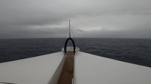Forward view from expedition cruise ship bow crossing Drake Passage under overcast sky toward Antarctica