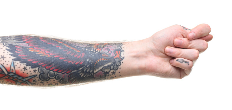 Man with tattoos showing fig gesture on white background, closeup