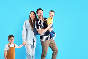 Fototapeta premium Portrait of happy family on light blue background, space for text