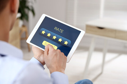 Man giving five-star rating on tablet indoors, closeup. Space for text