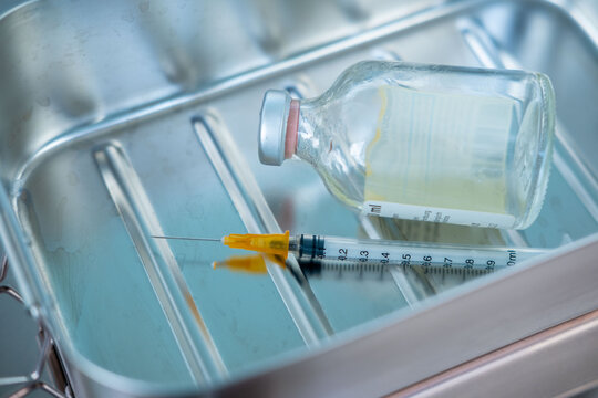 syringe and empty vial on clinical surface, end life decision, ethical dilemma euthanasia, assisted dying, vaccination sterile equipment, clinical sterile environment, control over life and death