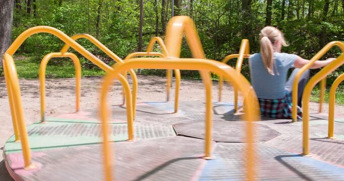 Girl gets pushed by boy on merry go round 4k
