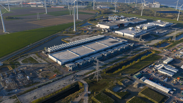 Aerial view of the Google data center complex surrounded by wind turbines and industrial infrastructure in Eemshaven, Groningen, Netherlands.