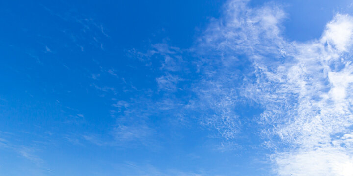 Panoramic vibrant blue sky background with soft white clouds and bright daylight for natural backdrop and clean outdoor design