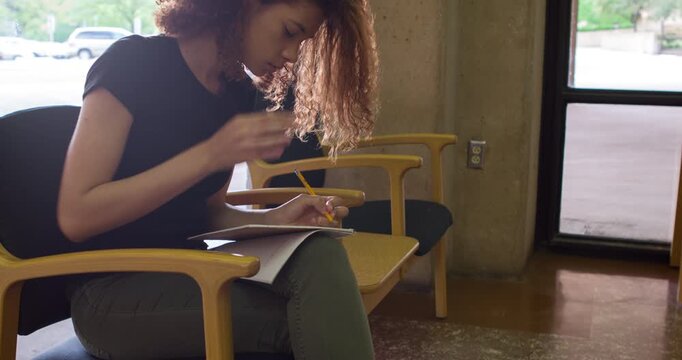 Young female writing in notepad with pencil 4k