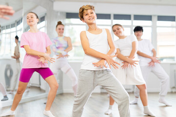Fototapeta premium Group of boys and girls rehearsing jazz funk dance in studio