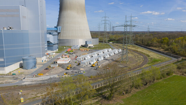 Aerial view of the RWE Westfalen power plant featuring a cooling tower, construction site with excavators, and high-voltage power lines in Hamm, Nordrhein-Westfalen, Germany.
