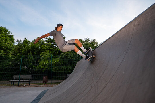 Skateboarder performing trick on half-pipe at skate park