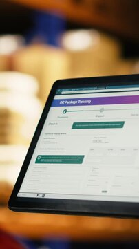 Vertical Video Tablet and scanner, verifying and organizing packages, african american staff in warehouse, production workflow highlights safety compliance. AWB cargo tracking in distribution center.