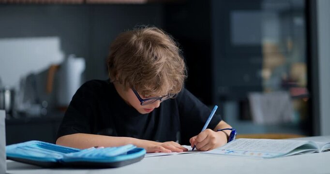 Little Boy Concentrates On Coloring Pages With Blue Crayon Amidst Scattered Art Supplies And Warm Sunlight