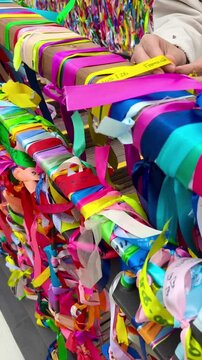 Mujer colocando un lazo de los deseos en los puentes de Aveiro, tradici&oacute;n rom&aacute;ntica portuguesa
